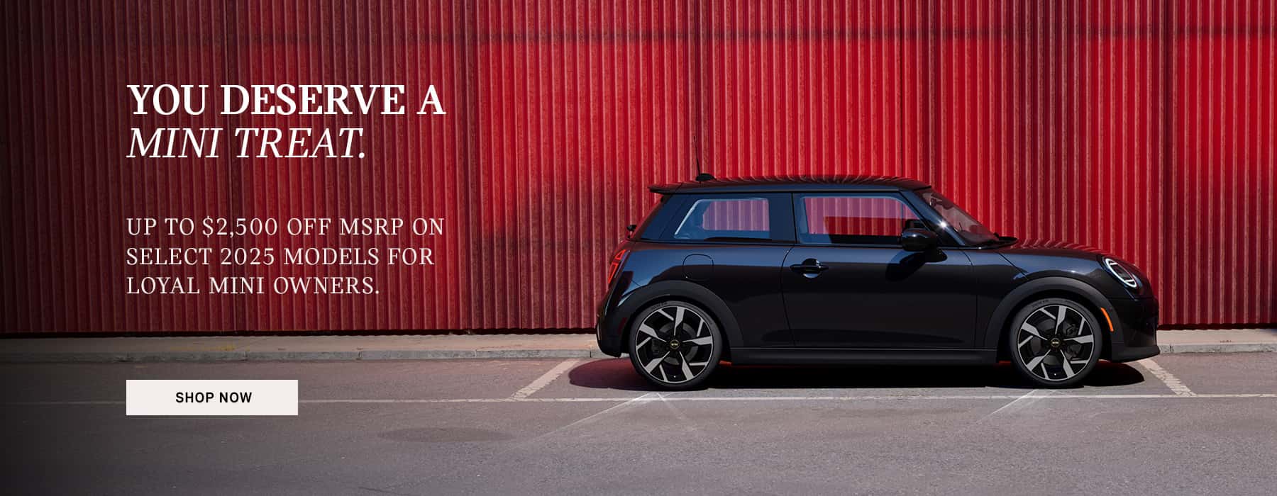Black MINI Cooper 2 Door parked in front of a red wall.