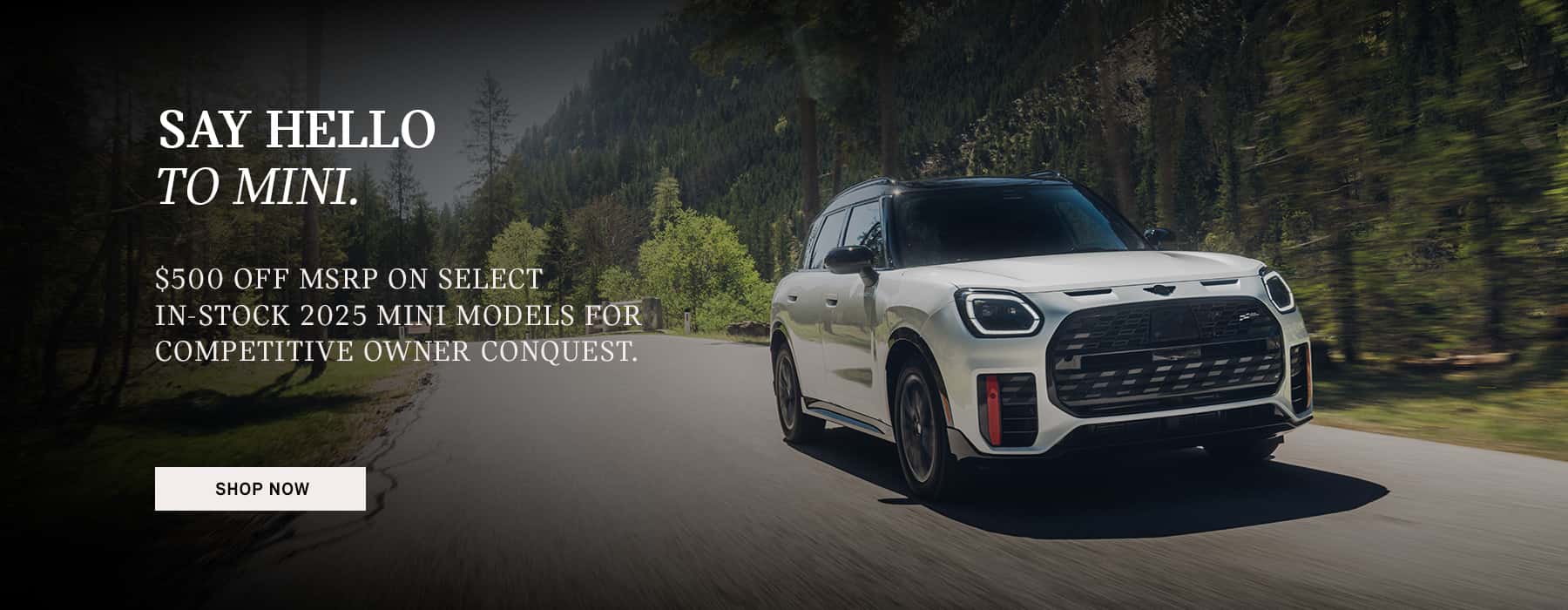 White Countryman JCW driving down a country road.