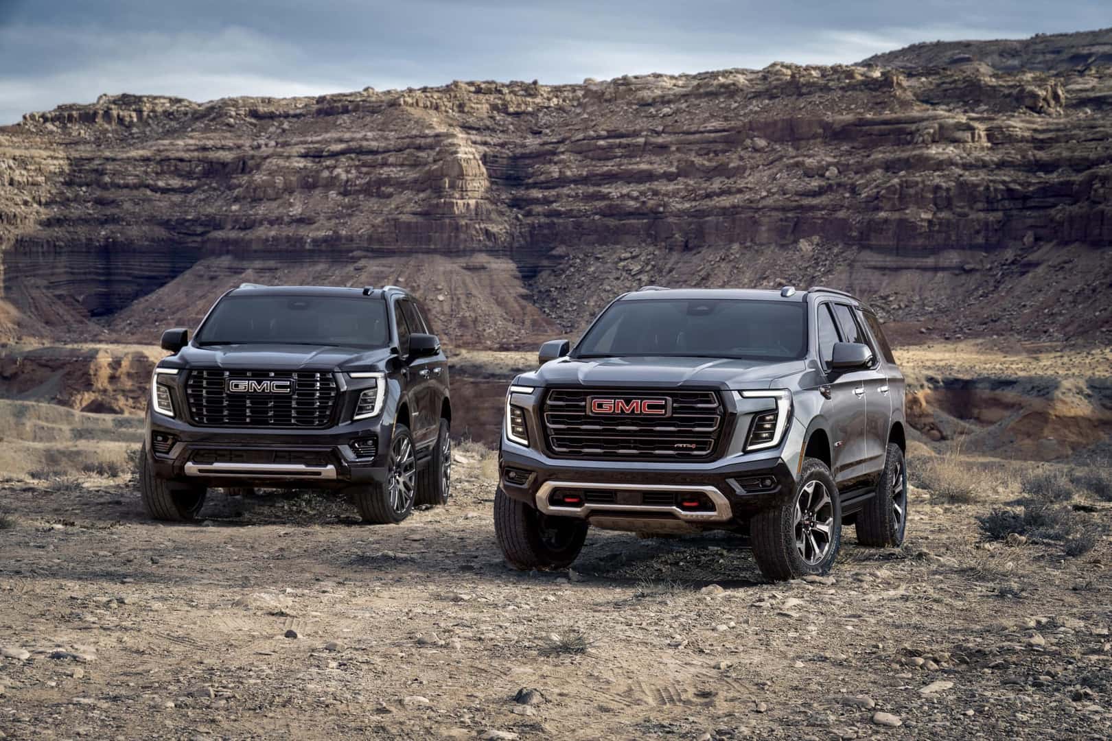Pack view of the 2025 GMC Yukon, including the AT4 Ultimate (right) and Denali Ultimate (left).