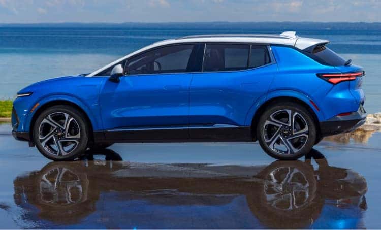 Blue Chevrolet SUV driving on a road covered in water