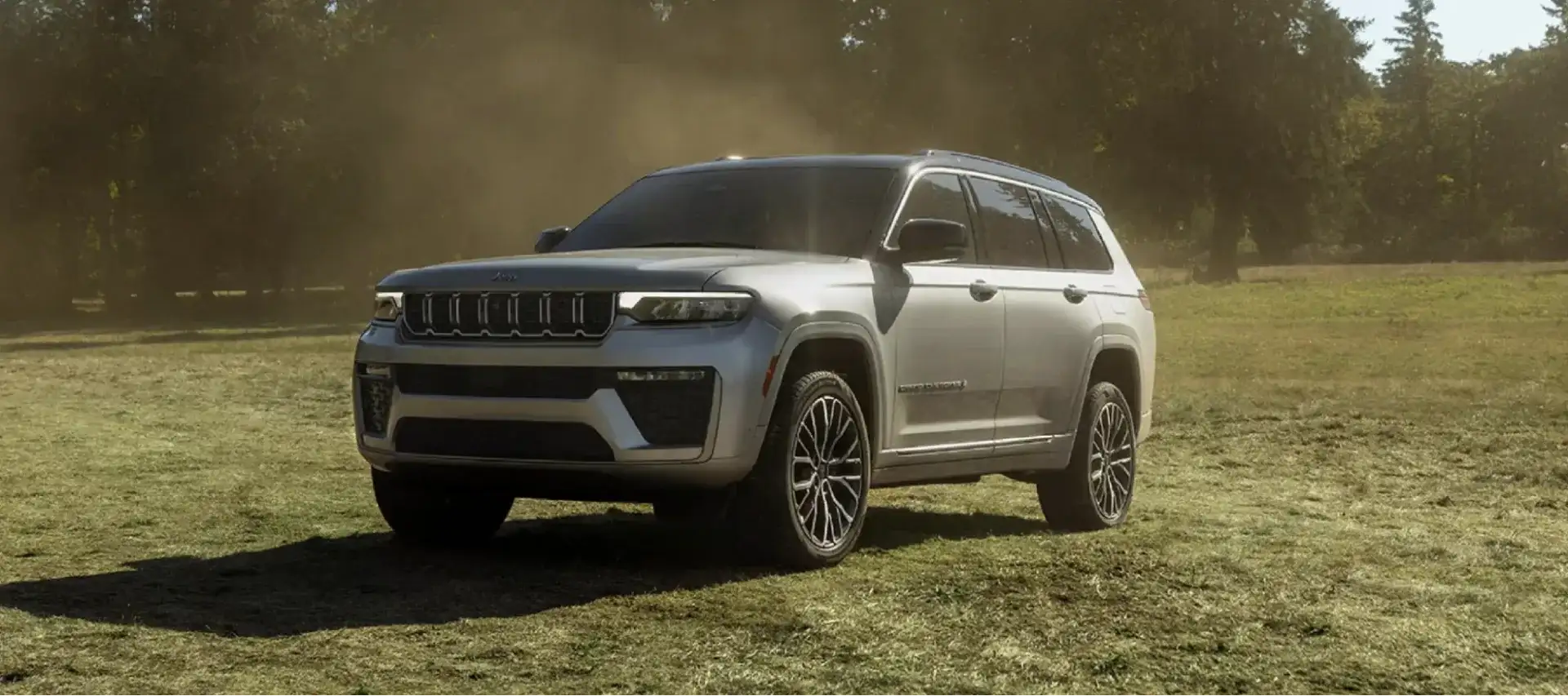 The 2026 Jeep Grand Cherokee L parked in a sunlit grassy clearing