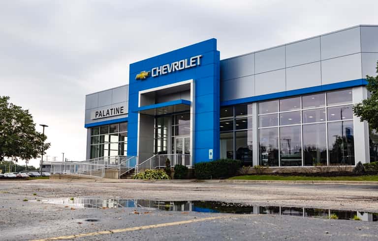 The Napleton Palatine Chevrolet showroom on East Lake Cook Road, with new Chevrolet trucks and SUVs parked out front.