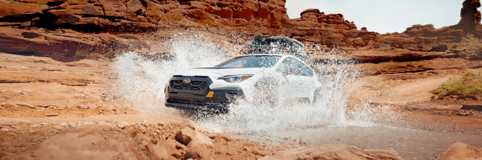 Subaru SUV driving on a rough off-road trail