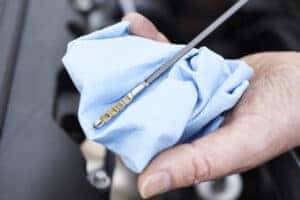 Close-Up Of Man Checking Car Engine Oil Level On Dipstick