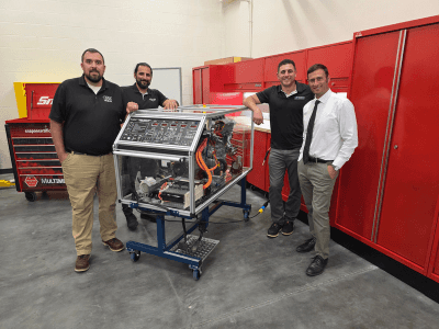Rich and Matt Nimey standing around a vehicle engine