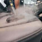 Professional car seat wash with steam cleaner closeup