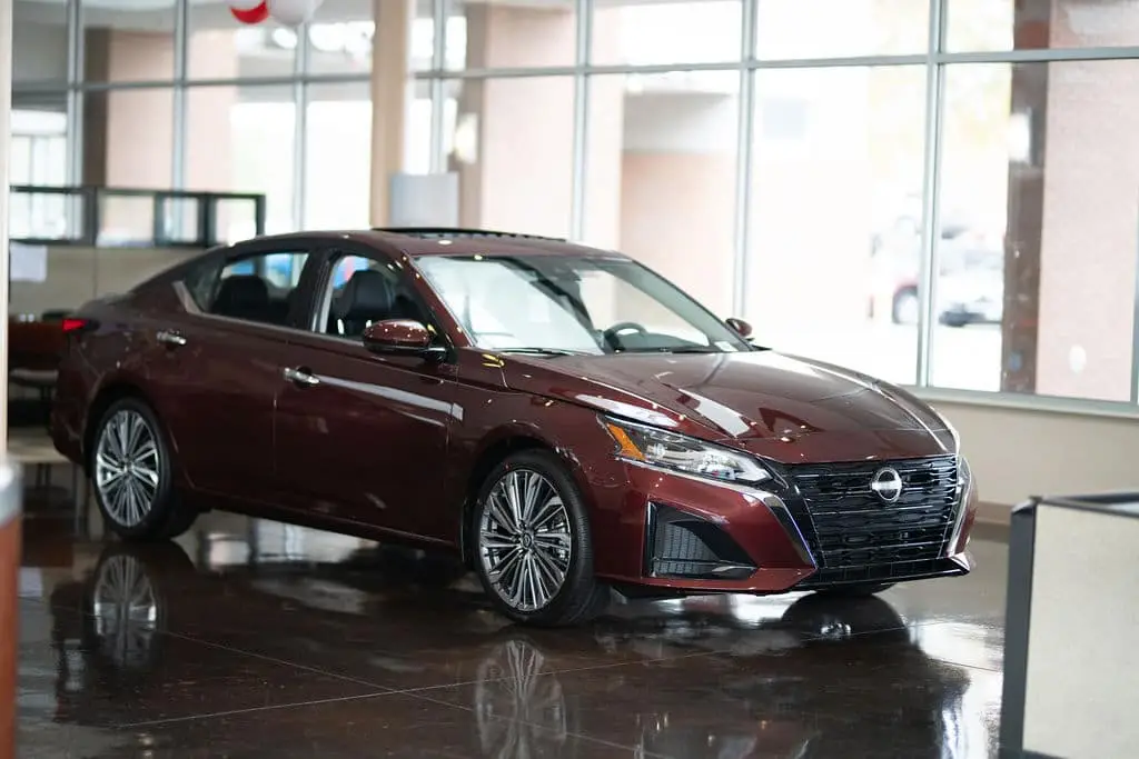 A front facing red Nissan car