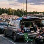 Used 2022 Nissan Armada with rear liftgate open at a Gainesville, GA high school football tailgate, stadium lights in background at dusk