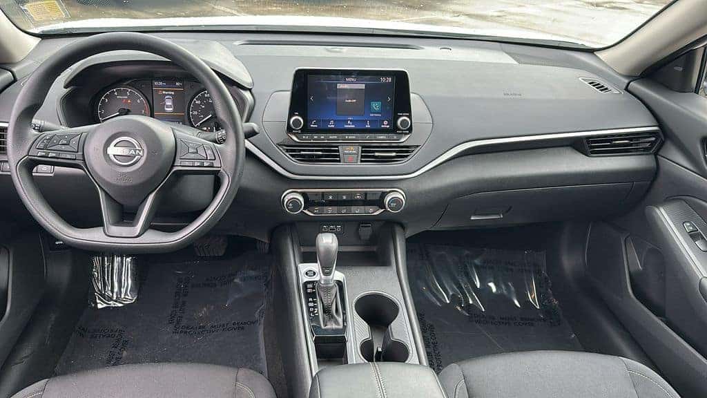 Clean interior and dashboard of a pre owned Nissan sedan
