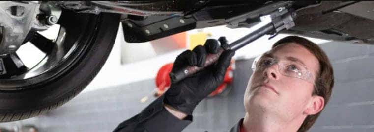 Certified Nissan technician performing maintenance to support peak fuel efficiency
