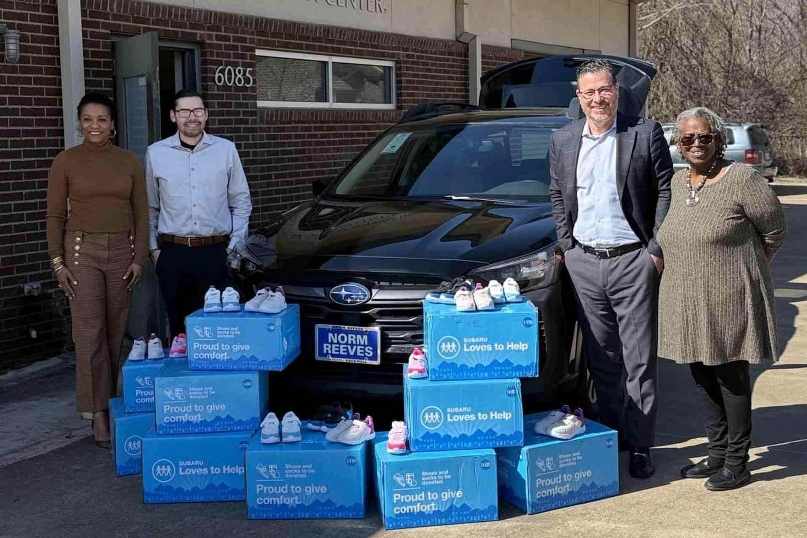 Community Involvement 4 employees standing by car