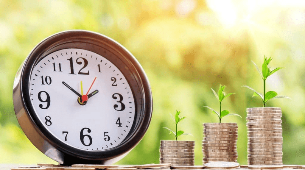 A few stacks of coins next to a clock