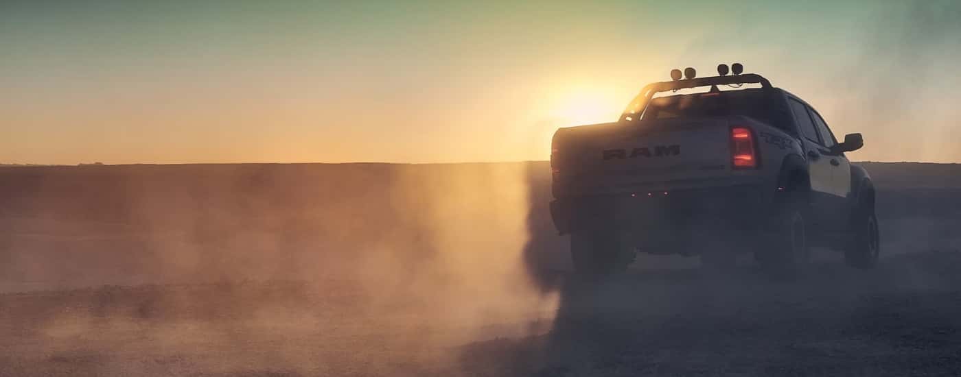 A grey 2023 Ram 1500 TRX parked in haze at sunset.