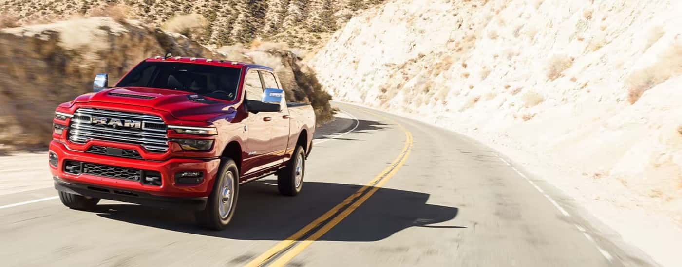 A red 2025 Ram 2500 driving to a Ram dealer in Castroville.