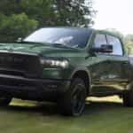 A green 2026 Ram 1500 Rebel towing a trailer.