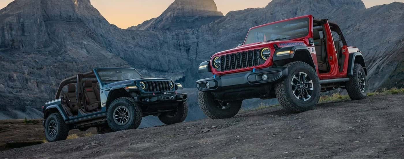 A grey and a red 2025 Jeep Wrangler for sale near San Antonio from the front.