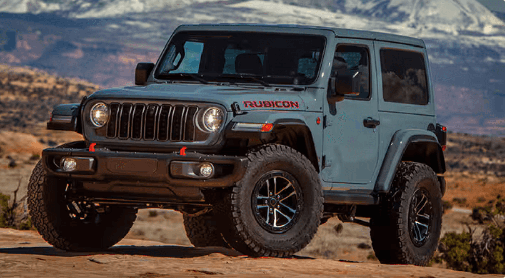 Blue 2025 Jeep Wrangler Rubicon 2-door parked off-road. 