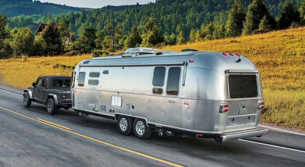 A gray 2026 Jeep Gladiator towing a trailer.