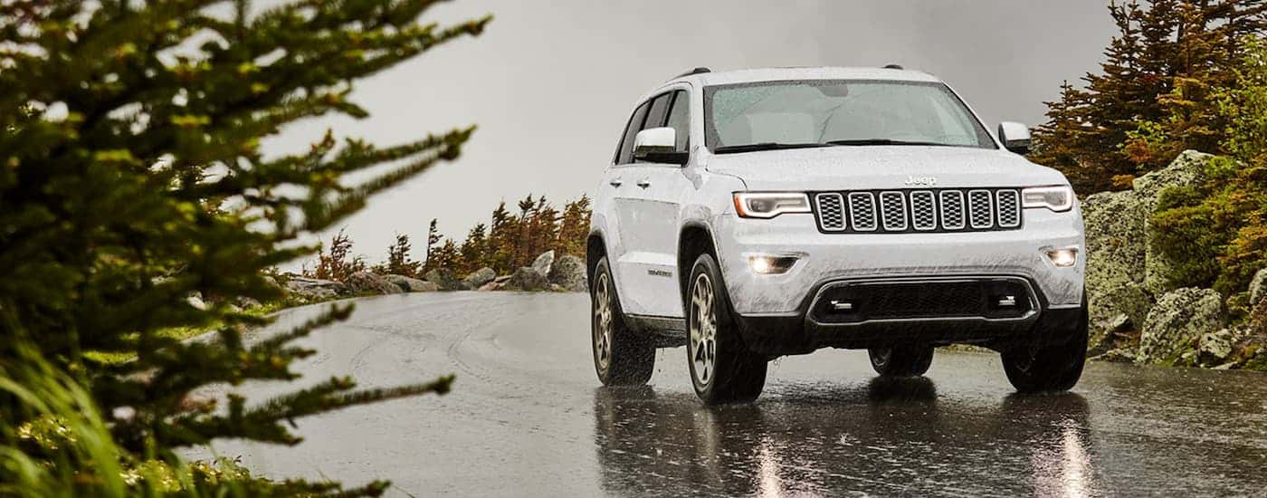 White 2021 Jeep Grand Cherokee driving down a foggy road