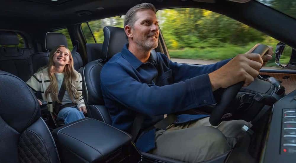 Two people driving in a 2026 Jeep Grand Cherokee.