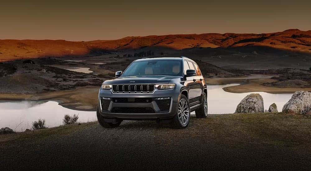 A gray 2026 Jeep Grand Cherokee for sale parked near water.
