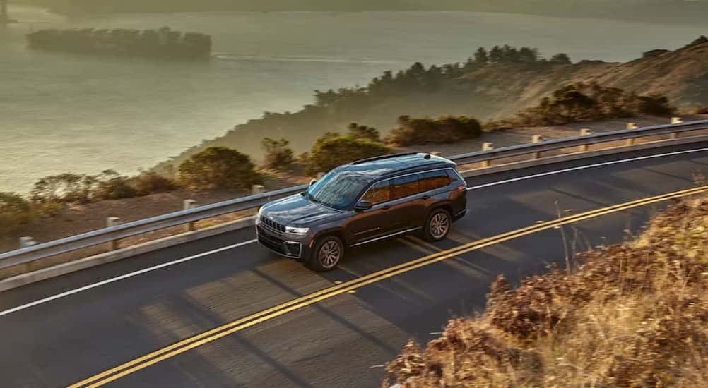 A gray 2026 Jeep Grand Cherokee driving on a highway.