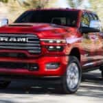 A red 2026 Ram 2500 driving on a road.
