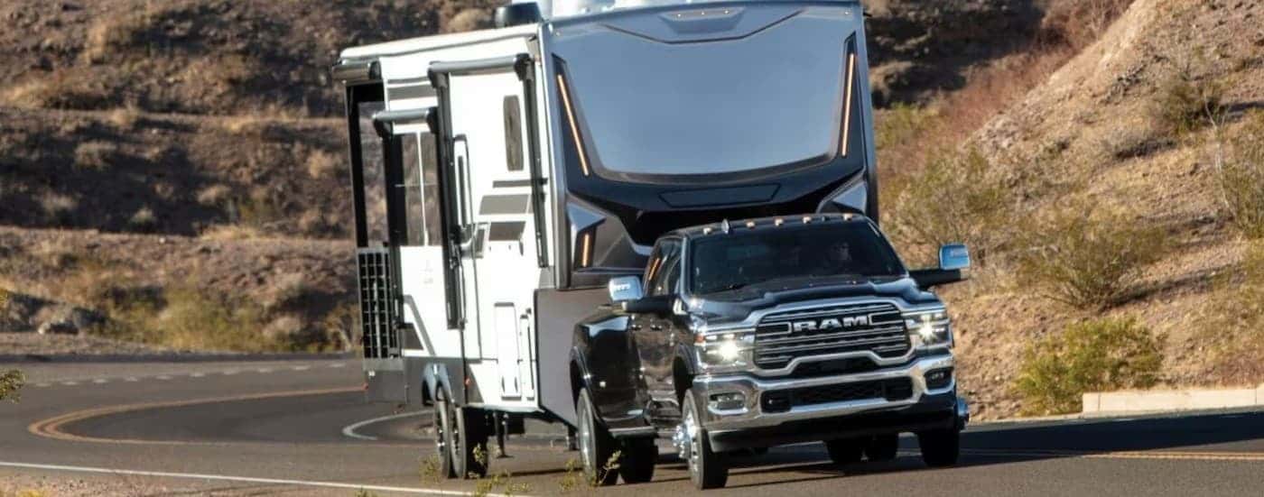 A black 2026 Ram 3500 towing a trailer.