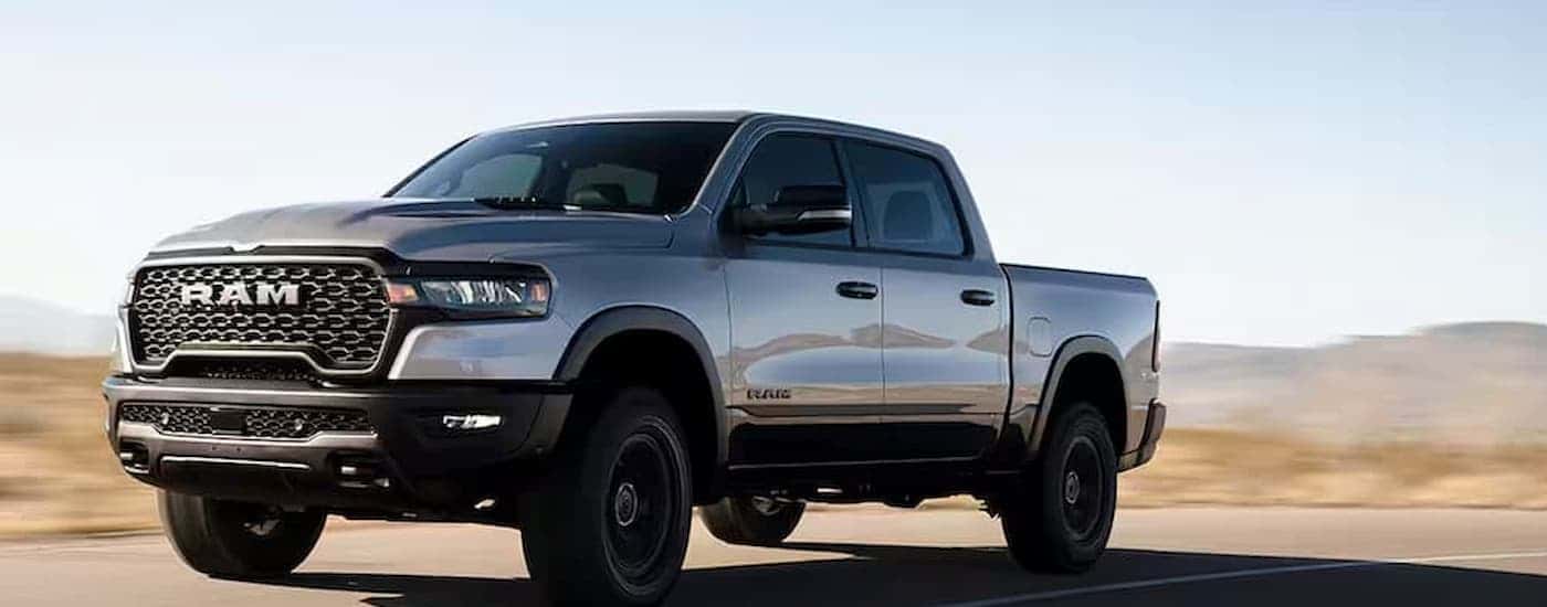A silver 2025 Ram 1500 driving on a highway