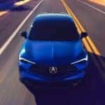 A blue 2025 Acura ADX driving on a highway.