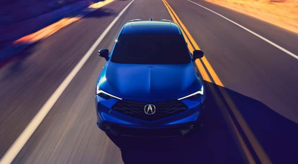 A blue 2025 Acura ADX driving on a highway.