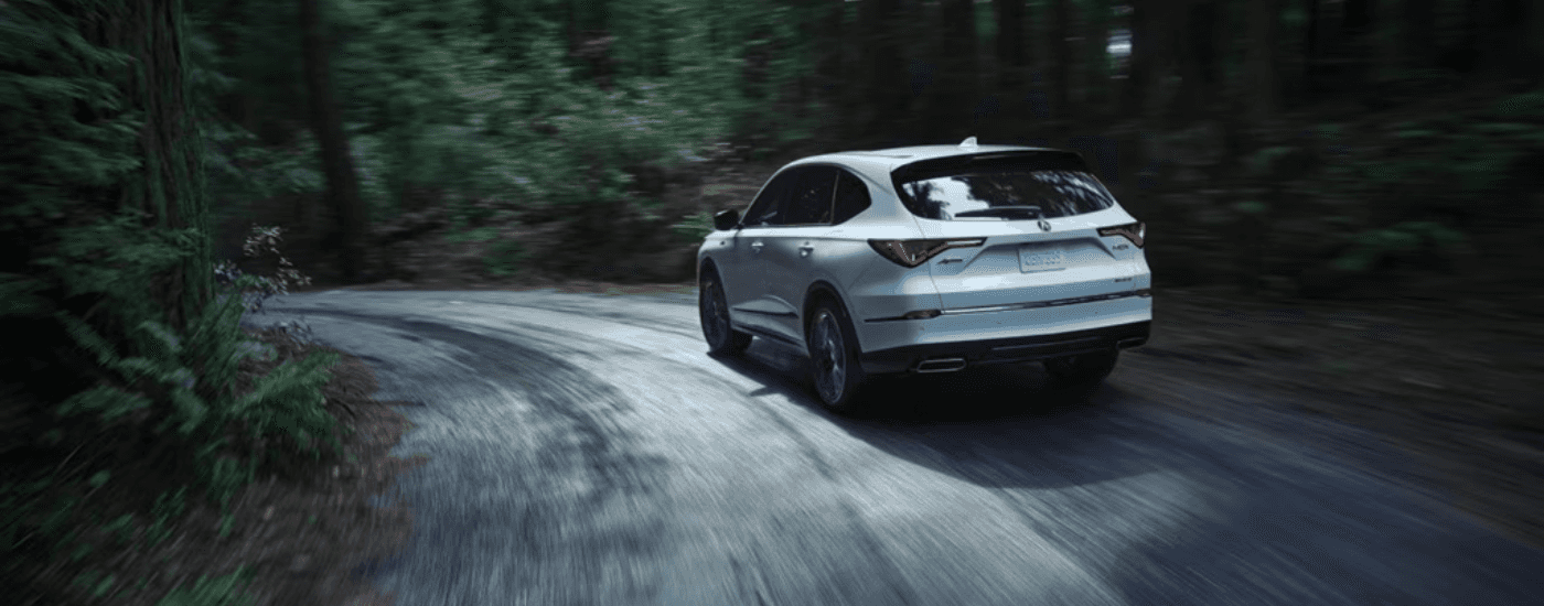 White 2026 Acura MDX rounding a bend