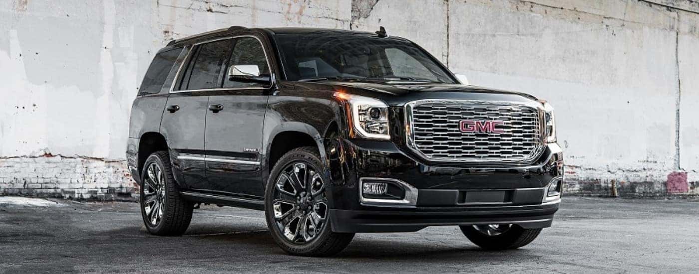 A black 2018 GMC Yukon Denali Ultimate is shown in front of a white wall.