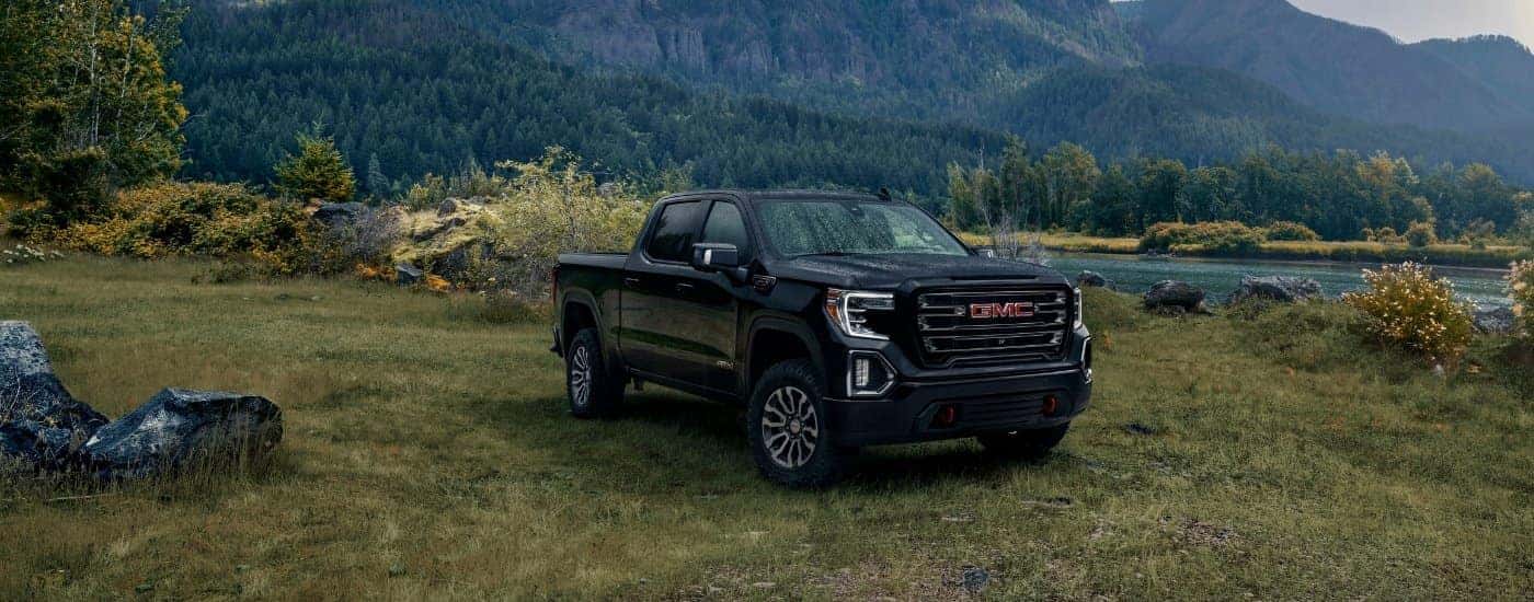 A black 2019 GMC Sierra 1500 AT4 is shown parked near a river.