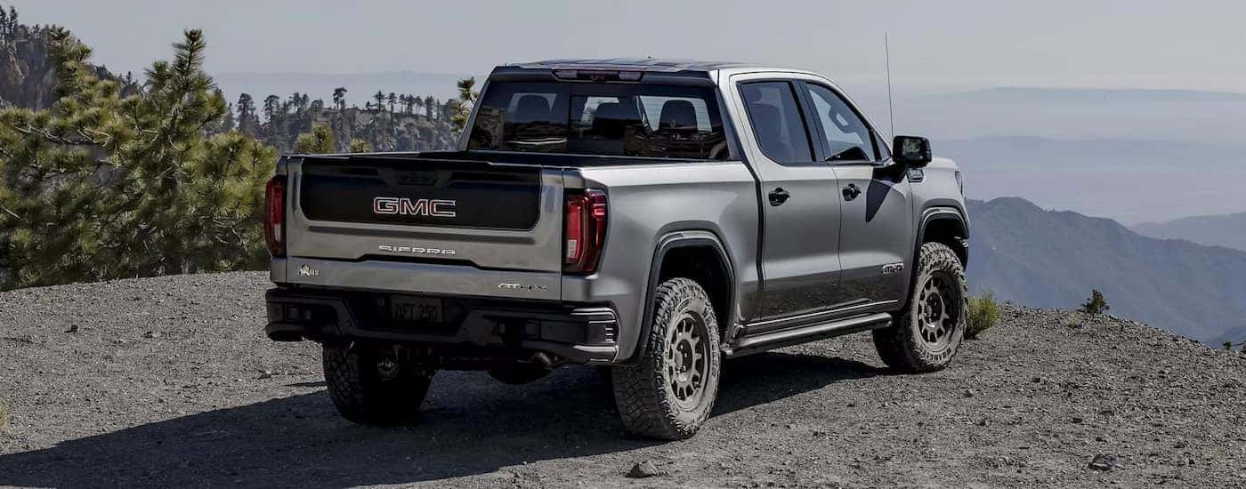 Rear view of a grey 2025 GMC Sierra 1500 for sale near Greensboro parked at a mountain overlook.