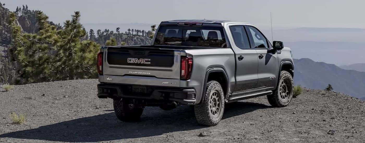 A silver 2025 GMC Sierra 1500 AT4X parked near a cliff.