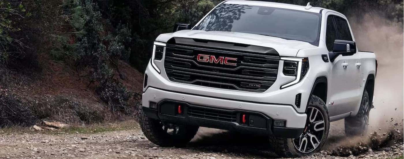A white 2025 GMC Sierra 1500 AT4X off-roading.