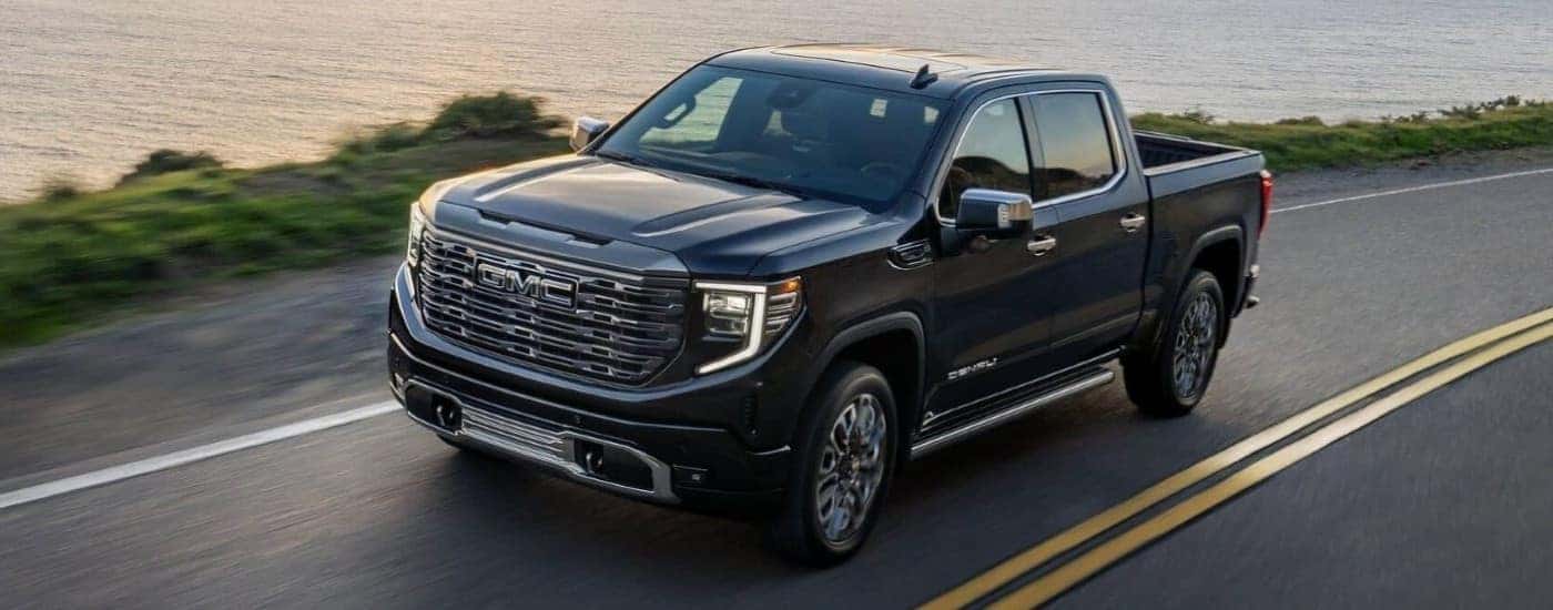 A black 2025 GMC Sierra 1500 for sale near Winston-Salem driving on a highway.