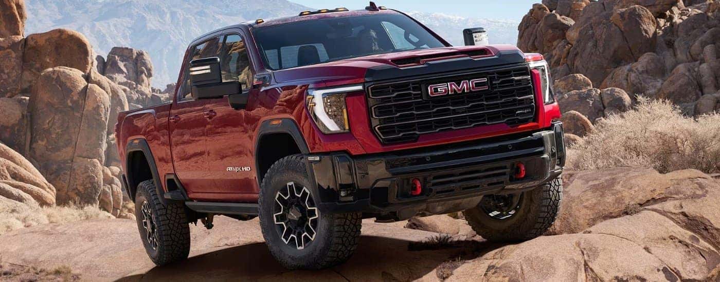 A red 2025 GMC Sierra 2500 AT4X parked off-road.