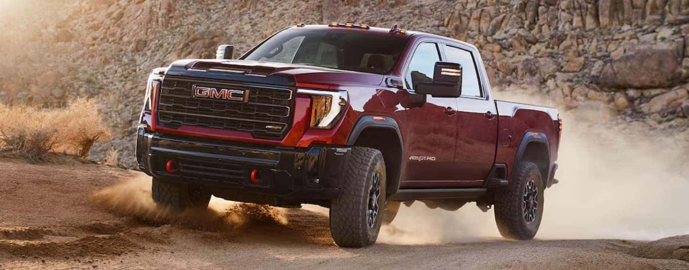 A red 2024 GMC Sierra 2500 AT4X driving off-road.