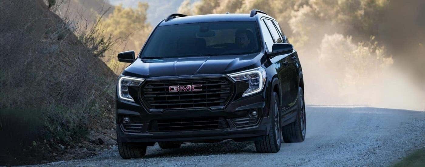 A black 2022 GMC Terrain driving to a used car dealer in Kernersville.
