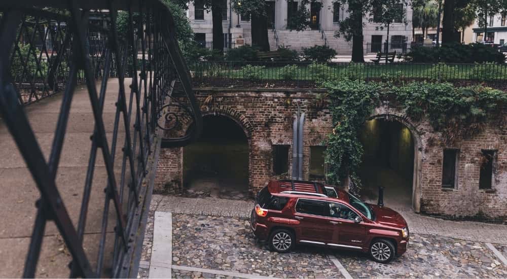 A red 2017 GMC Terrain Denali parked near a bridge.