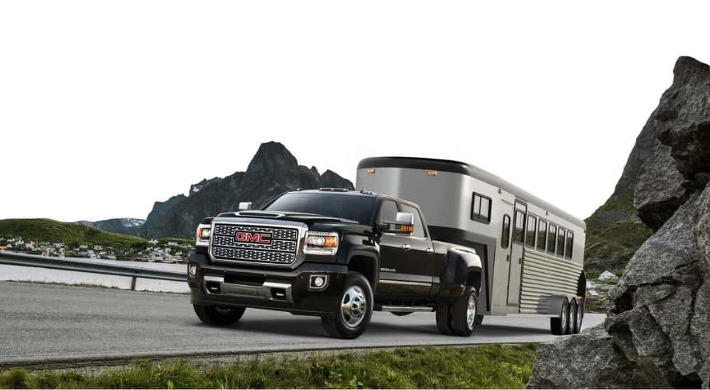 A black 2018 GMC Sierra 3500 HD towing a trailer.