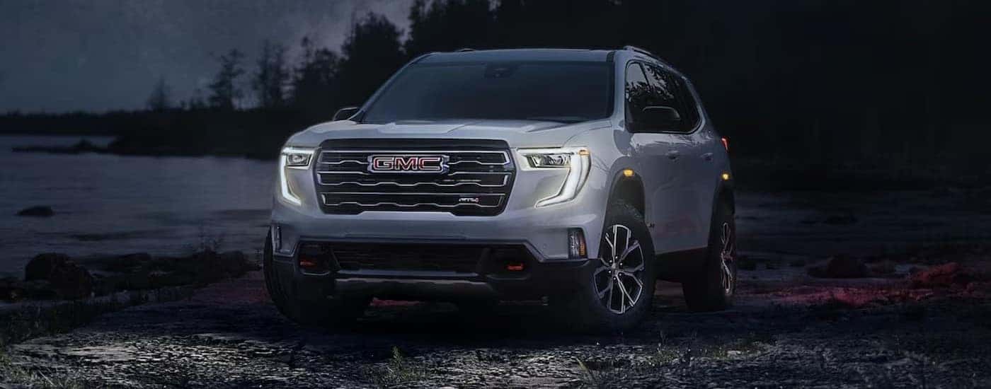 A white 2024 GMC Acadia AT4 parked after viewing a used GMC for sale.