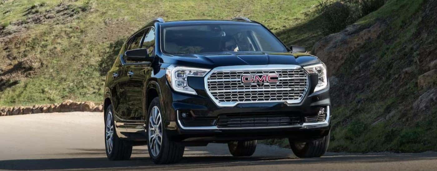 A black 2024 GMC Terrain driving during the day.