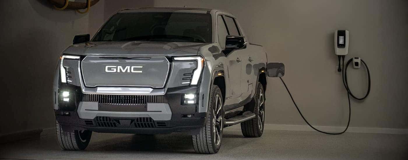 Grey 2024 GMC Sierra EV charging in a garage