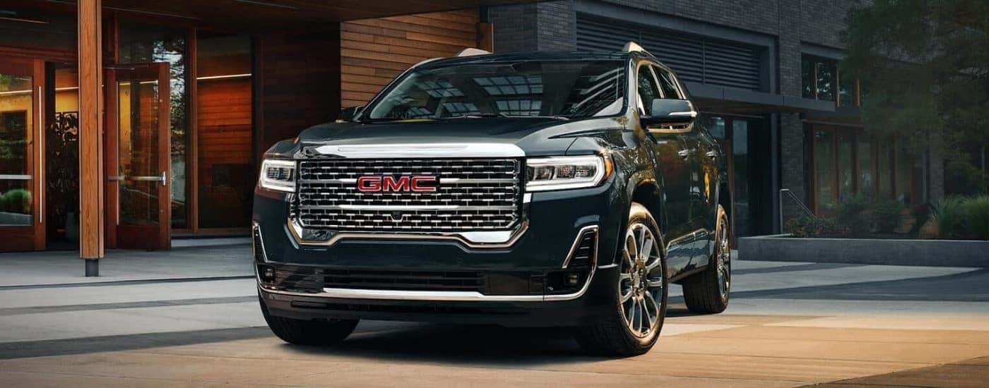 A black 2023 GMC Acadia Denali parked outside a building