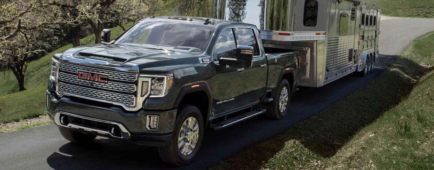 A black 2022 GMC Sierra 2500 HD towing a horse trailer