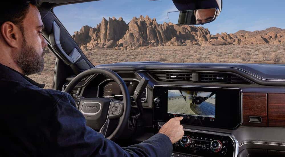 Man using the infotainment screen in a 2025 GMC Sierra 3500HD