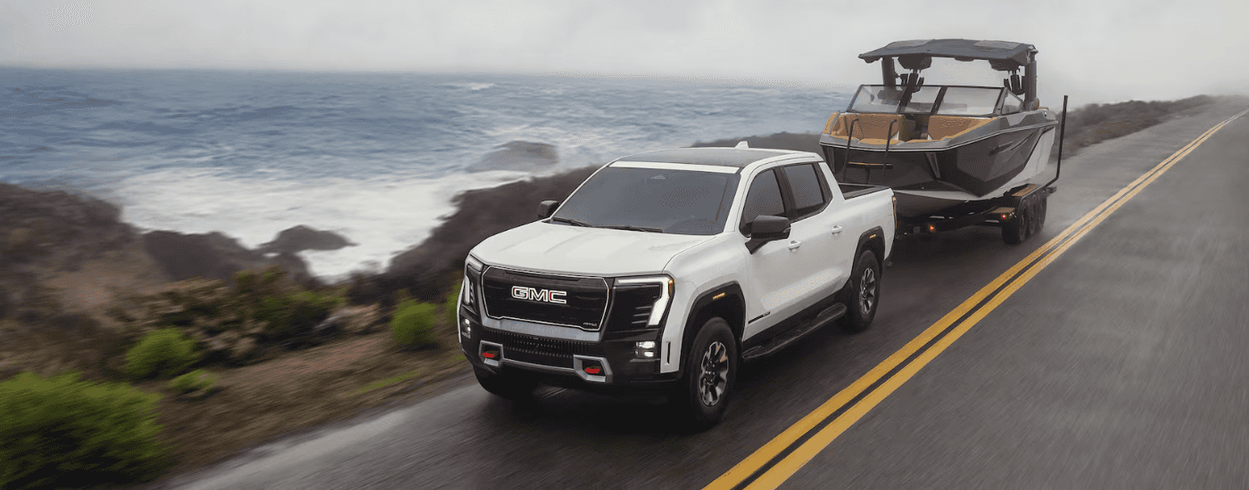 White 2026 GMC Sierra EV towing a boat to look at trucks for sale
